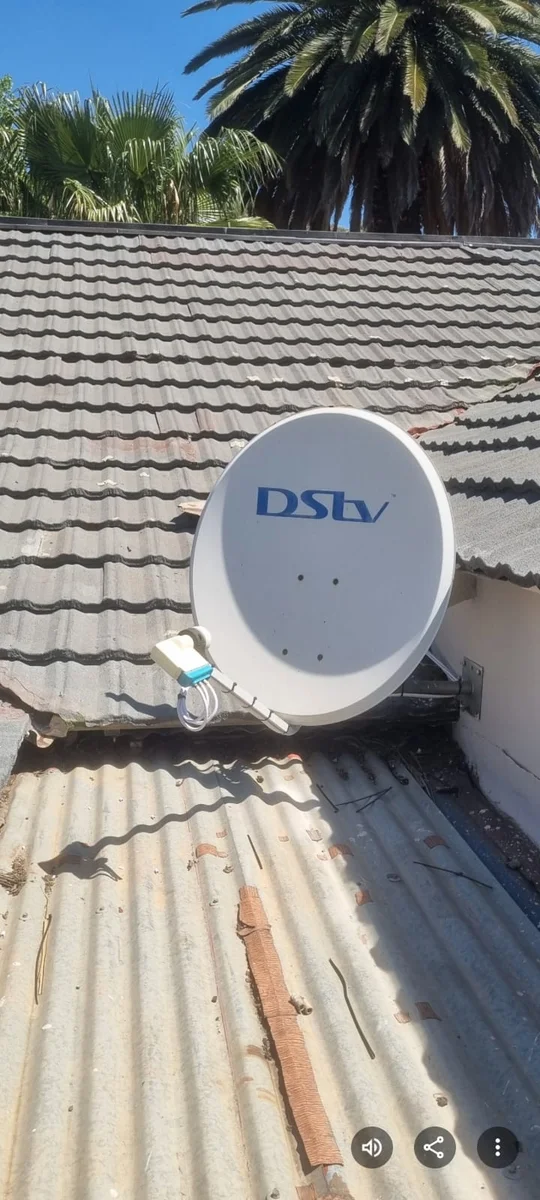 A DStv satellite dish mounted and aligned on a tiled roof in Sandton